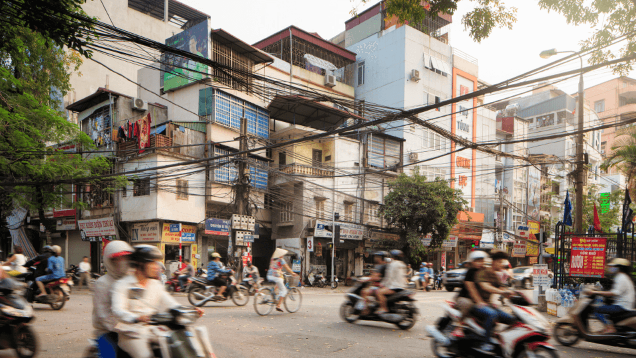 Cyklister och mopedister trafikerar en gata i Vietnam