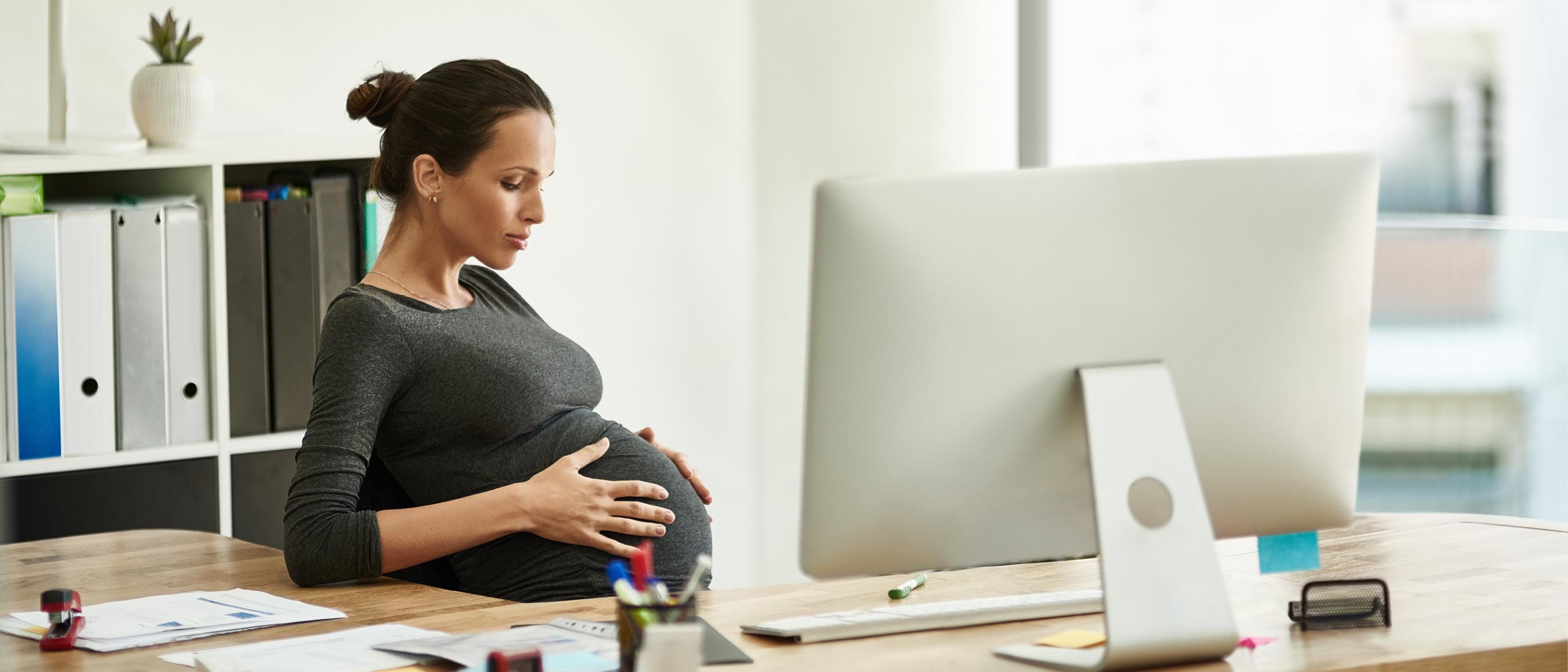 Gravid kvinna sitter på kontoret