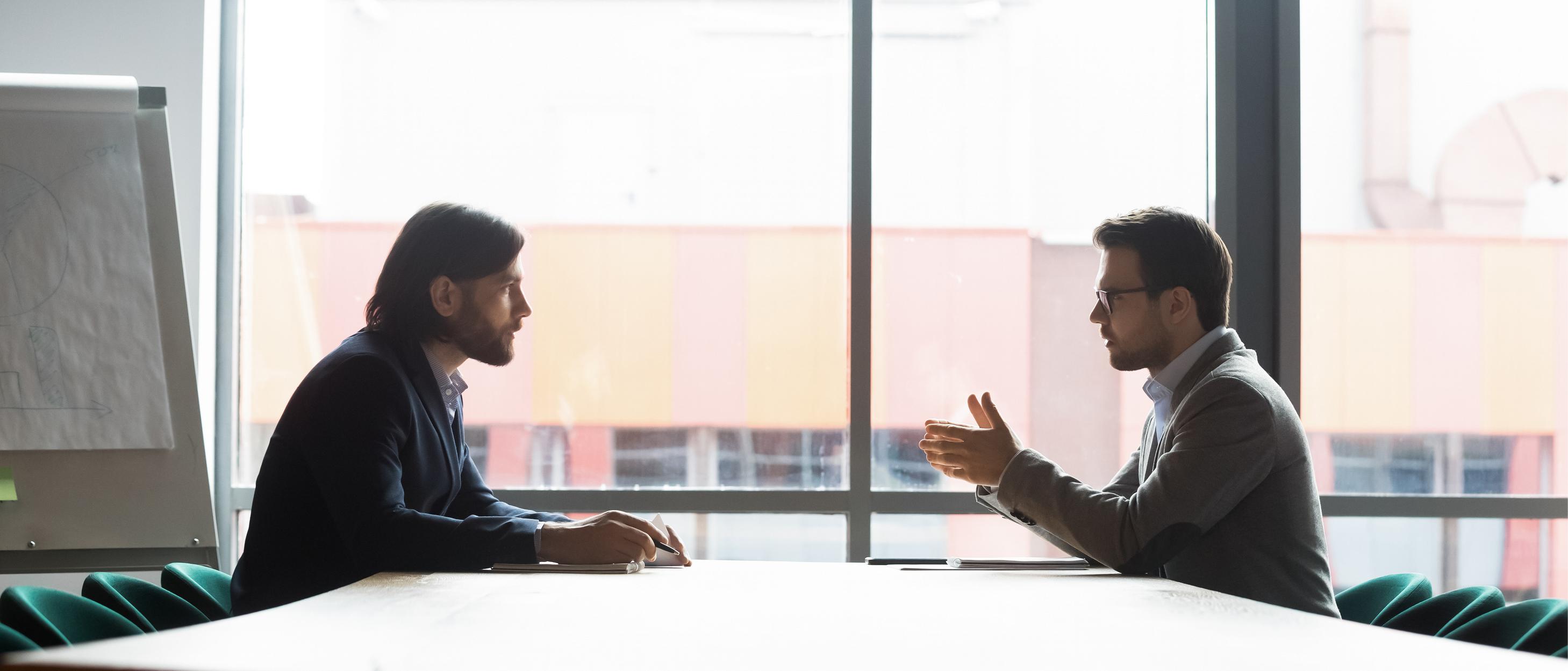 Två män pratar med varandra under ett jobbmöte
