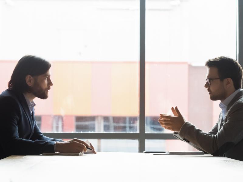 Två män pratar med varandra under ett jobbmöte